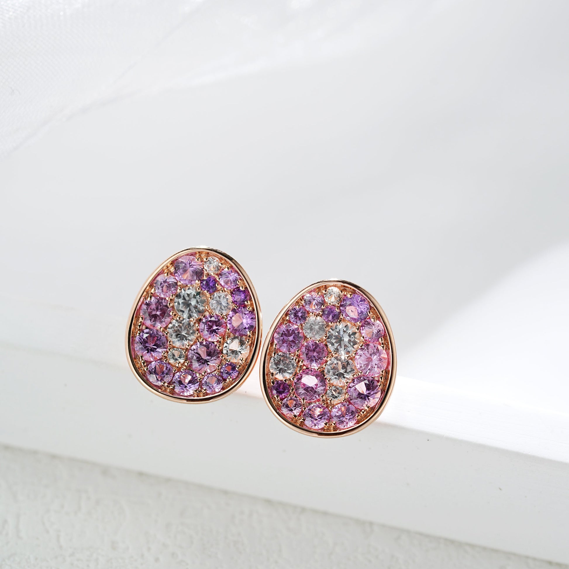 Pair of pink gemstone earrings on a white background