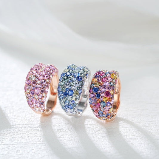 Three colorful gemstone rings on a white background