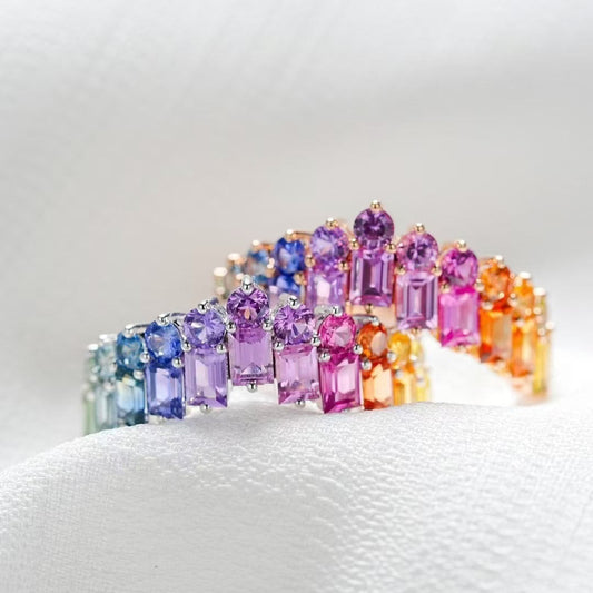 Multicolored gemstone ring on a white cushion
